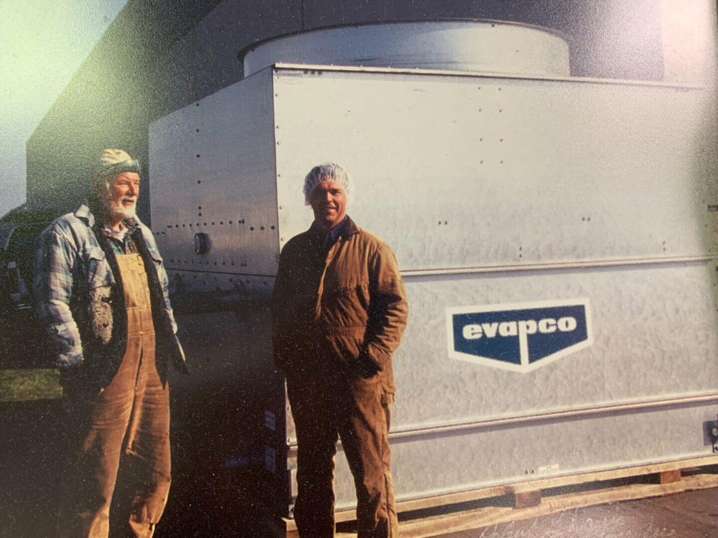 Midwest Mechanical Systems technicians beside an industrial Evapco refrigeration unit