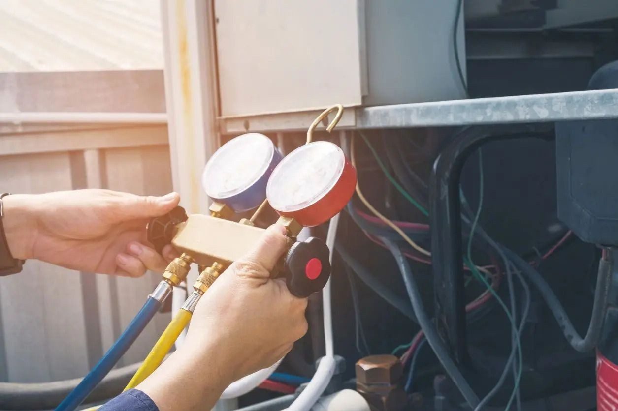 Midwest Mechanical Systems technician using gauges to service commercial HVAC equipment in Cincinnati